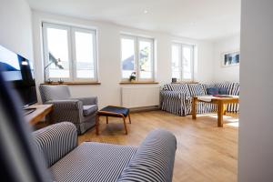 a living room with couches and a tv and windows at Conzen Hof am Hennesee in Erflinghausen