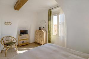 a bedroom with a bed and a chair and a window at Superbe appartement centre Ajaccio in Ajaccio