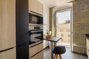 a kitchen with a table and a microwave and a window at Superbe appartement centre Ajaccio in Ajaccio