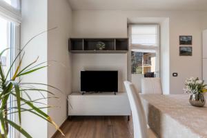 a living room with a table and a television at Villa Vacanze Pink Lady in Tuenno