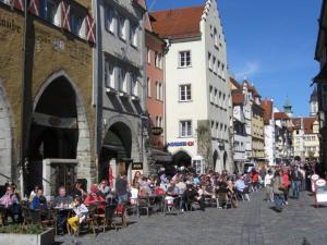 a crowd of people sitting in chairs on a city street at Rosarote Insel - La Vie en Rose in Lindau