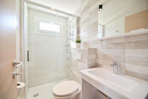 a white bathroom with a toilet and a sink at Mobile Homes Krk Silo in Šilo +67 photos