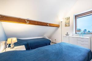 a bedroom with two blue beds and a window at Ferienwohnung Albatros Steinhude in Wunstorf