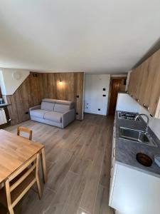 a kitchen and living room with a table and a couch at L’Angolo del Paradiso in Cogne