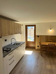 a kitchen with a sink and a table with a dining room at L’Angolo del Paradiso in Cogne +8 photos