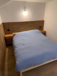a bedroom with a bed with a wooden headboard at L’Angolo del Paradiso in Cogne