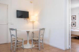 a table with two chairs and a tv on a wall at Can Manuel in Felanitx
