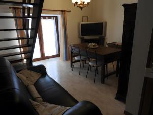 a living room with a couch and a dining room table at Gite De La Guillone in Savignac