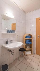 a bathroom with a sink and a mirror and a stool at Springhansenhof in Oppenau