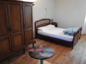 a small bedroom with a bed and a table at Gite De La Guillone in Savignac +11 photos