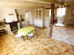a living room with a table and chairs and a fireplace at Gite De La Guillone in Savignac