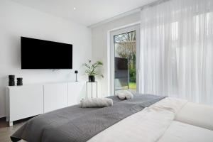 a white bedroom with a bed with two pillows on it at Apartment Aura in Mengen
