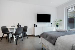 a bedroom with a table and a tv on a wall at Apartment Aura in Mengen