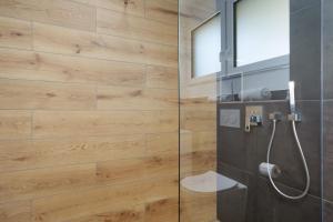 a bathroom with a shower with a wooden wall at Apartment Aura in Mengen +15 photos