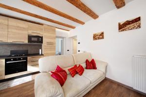 a living room with a white couch and red pillows at Appartamento Bucaneve - Padola in Padola