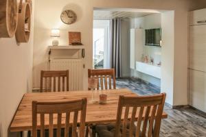 a kitchen and dining room with a wooden table and chairs at Ferienwohnung Malerstübchen in Willingen