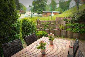 a wooden table with two potted plants on a patio at Ferienwohnung Malerstübchen in Willingen