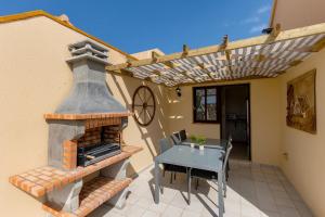 a patio with a table and an outdoor oven at Te Mahana Nei House in Costa Calma