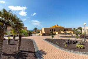 a resort with palm trees and a building at Te Mahana Nei House in Costa Calma