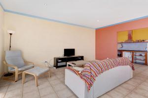 a living room with a couch and a desk and a tv at Casa Sirius in Tijarafe