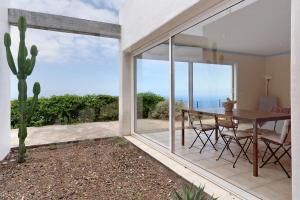 a dining room with a table and a large window at Casa Sirius in Tijarafe