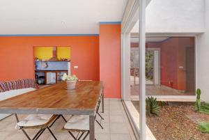 a dining room with orange walls and a wooden table at Casa Sirius in Tijarafe
