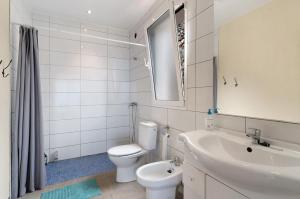 a white bathroom with a toilet and a sink at Casa Sirius in Tijarafe +20 photos