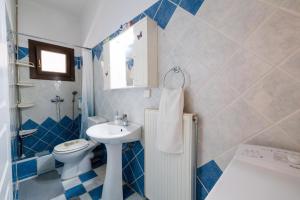 a blue and white bathroom with a sink and a toilet at Breathing Apartments in Virós +31 photos