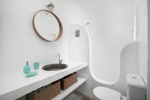 a white bathroom with a sink and a mirror at Karavi in Rámos