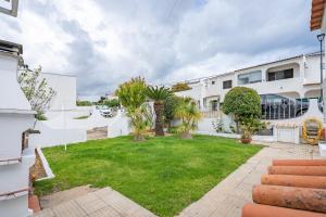 a backyard with a lawn in front of a building at Villa Raposo em Porches in Porches