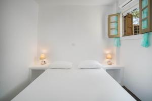 a white bedroom with a bed and a window at Karavi in Rámos