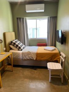 a small bedroom with a bed and a window at Hotel Windsor Mendoza in Mendoza