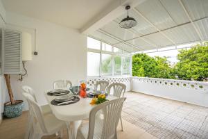 a white dining room with a table and chairs at Villa Raposo em Porches in Porches