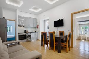 a kitchen and dining room with a table and chairs at Moradia dos Castelos Amarelo in Santarém