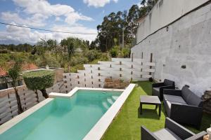 an outdoor swimming pool with lawn chairs and a patio at Moradia dos Castelos Amarelo in Santarém