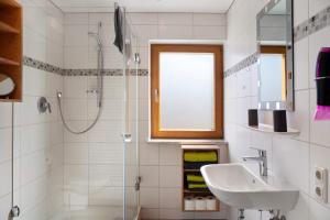 a white bathroom with a sink and a shower at Ferienwohnung Waxensteinblick in Grainau +15 photos