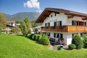 a large house with a balcony and a yard at Ferienwohnung Waxensteinblick in Grainau