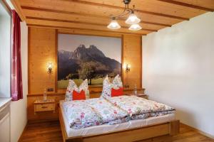 a bedroom with a bed with a picture on the wall at Ferienwohnung Waxensteinblick in Grainau