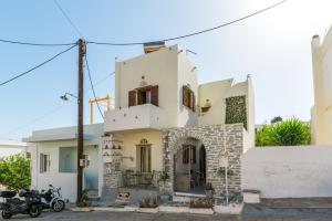 a white house with a motorcycle parked in front of it at En Tino 3 in Tinos