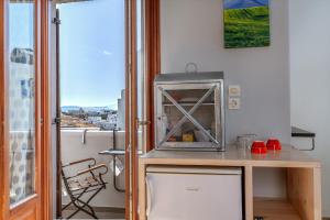 a small kitchen with a microwave on a table at En Tino 3 in Tinos