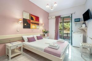 a bedroom with a large bed with pink walls at Nontas Home 24 in Kalamitsi +16 photos