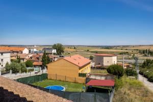 a view of a town with a yellow building and a yard at Casa Alval in Villacastín