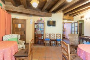 a living room with a table and chairs and a tv at Casa Alval in Villacastín