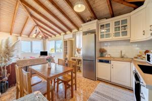 a kitchen and dining room with a wooden ceiling at Arianna Grand apartment in Corfu