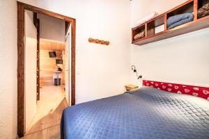 a bedroom with a blue bed with a red headboard at Appt bien agencé, bien placé-Châtel in Châtel