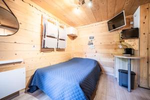 a bedroom with a bed in a wooden room at Appt bien agencé, bien placé-Châtel in Châtel
