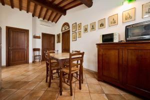 a dining room with a table and chairs and a tv at Poggio Diavolino - Suvereto in Suvereto