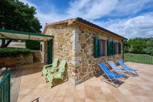 a patio with lawn chairs and a building at Poggio Diavolino - Suvereto in Suvereto