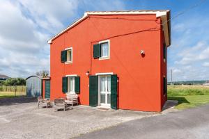 a red building with two chairs in front of it at Casa Simi - Holiday Home in Chiesina Uzzanese
