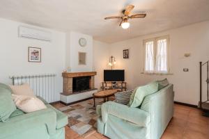 a living room with two chairs and a fireplace at Casa Simi - Holiday Home in Chiesina Uzzanese